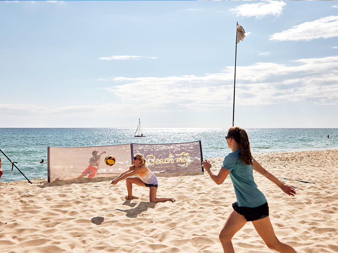 Participants play beach volleyball in Sardinia