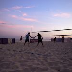 Beachvolleyballspiel bei Sonnenuntergang