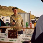 Teilnehmender des Beachvolleyball Camps bestellt Lemonaid an Beachbar