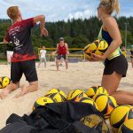 Trainerin erklärt Beachvolleyball
