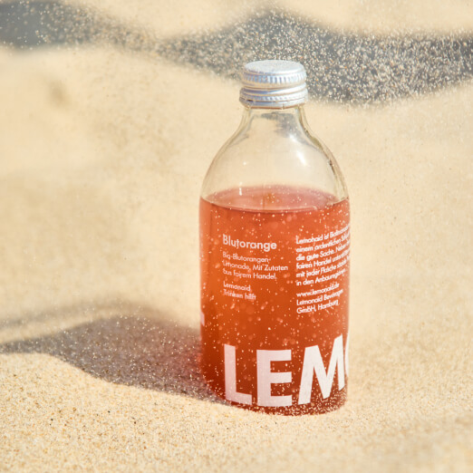 Lemonaid Blutorange Flasche im Sand