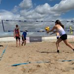 Teilnehmende Jugendliche spielen Beachvolleyball im Camp
