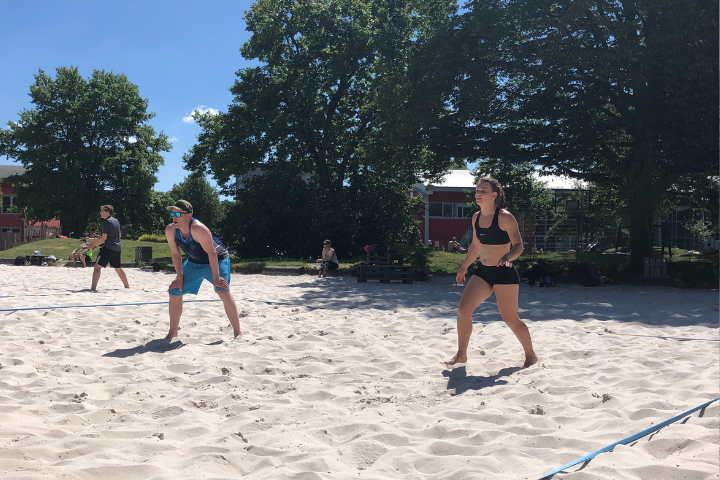 Mann und Frau im Sand auf Beachvolleyballfeld im Beach Hamburg