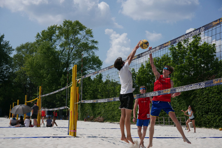 Jugendliche bei Blockaktion am Netz beim Beachvolleyball